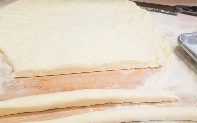 Flatten out the gnocchi dough and cut about half inch strips. 