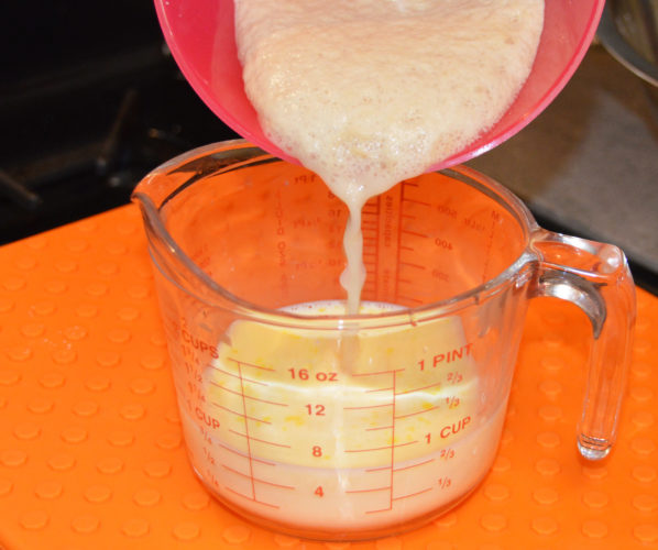 Adding the proofed yeast to the milk and egg mixture. 