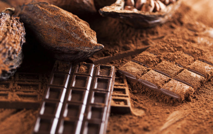 Chocolate bar, candy sweet, cacao beans and powder on wooden background