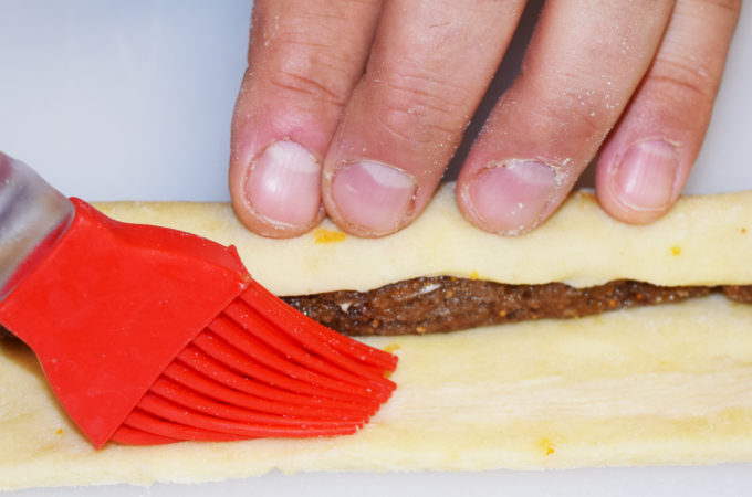 Fold the dough over the filling. Dampen the opposite end with a little water or eggwash.